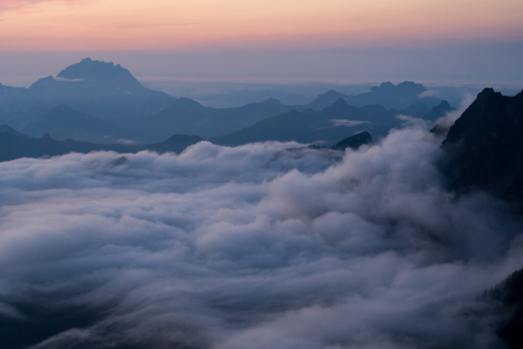 view from vesper peak while clouds roll in creating a blanket of undercast clouds cover